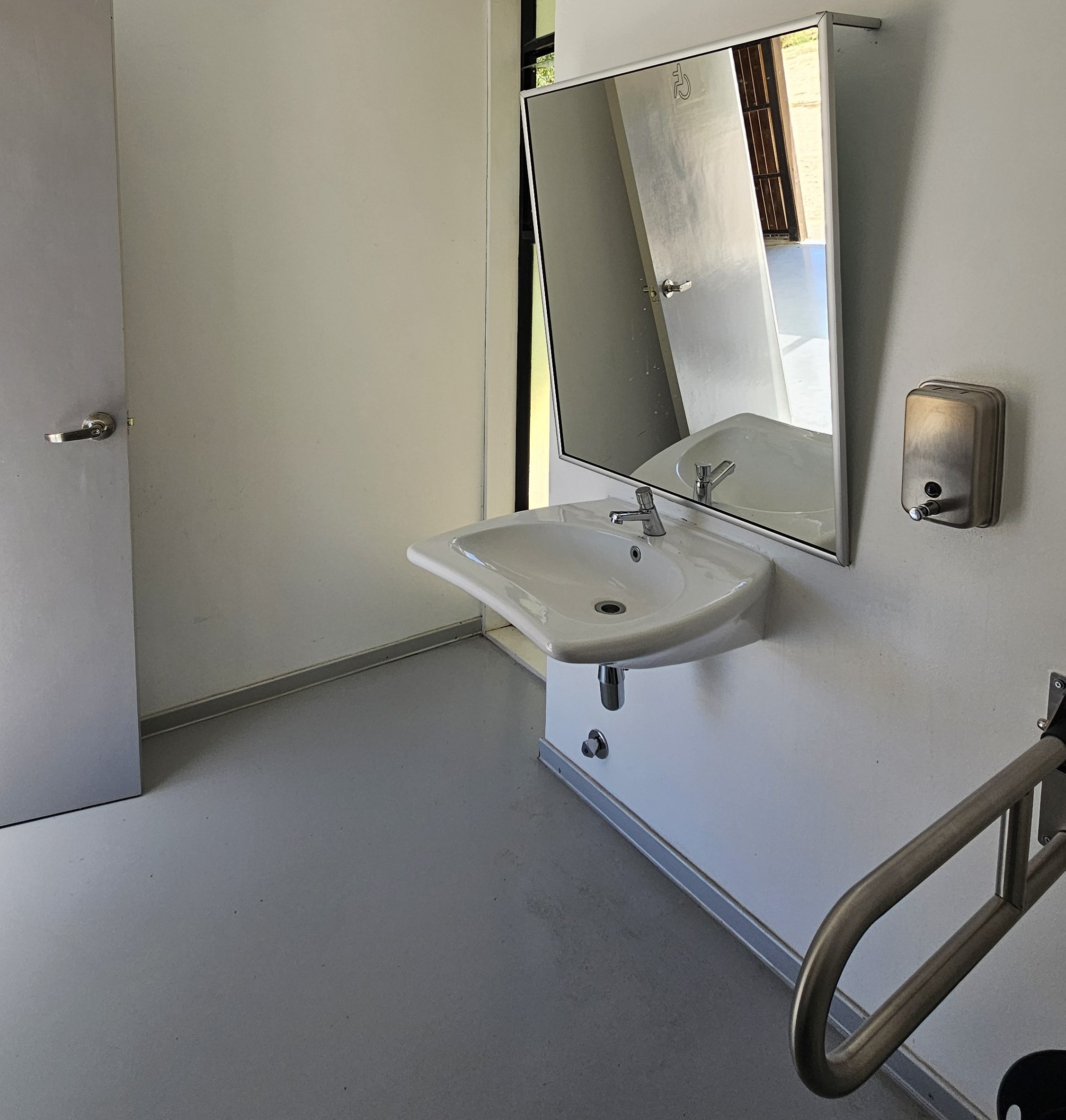 fotografía del baño accesible desde otro ángulo, cuenta con todos los aspectos necesarios para ser completamente accesible